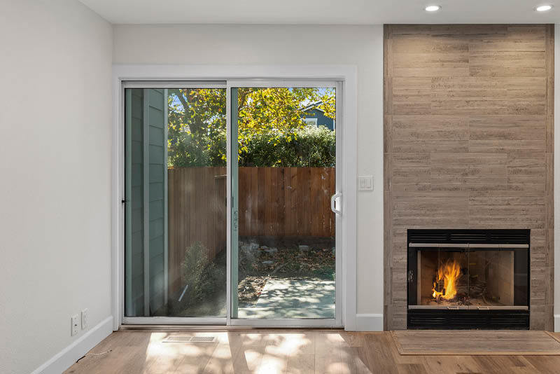 Interior of remodeled house with outside balcony doors and fireplace.