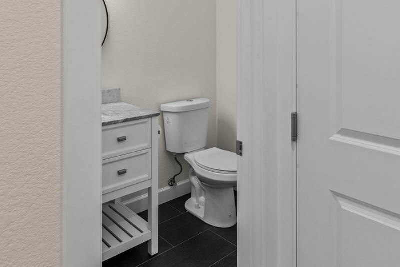 Remodeled white decor bathroom interior with cabinets and toilet.