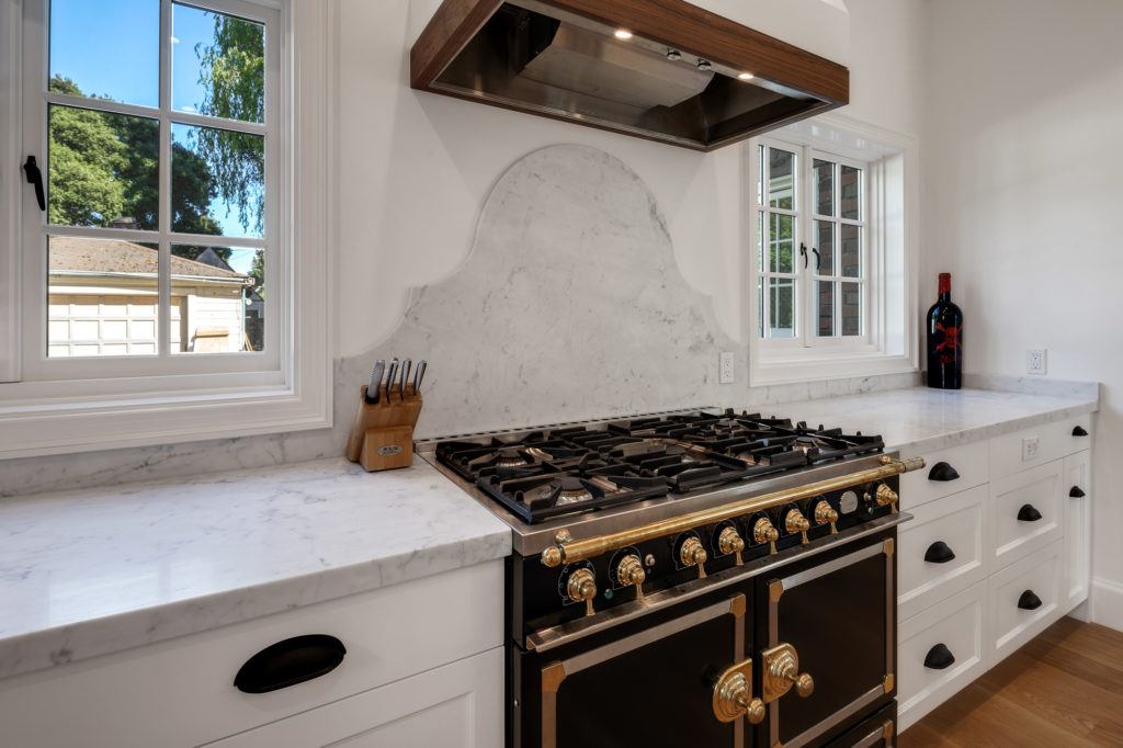 A black and gold antique replica stove in a newly-remodeled kitchen helps maintain a historic feel.