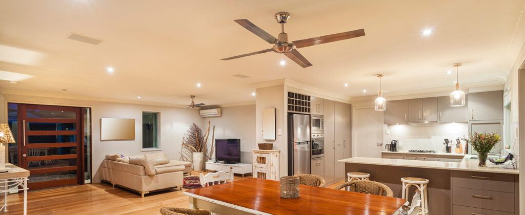 remodeled kitchen, dining, and family room area with modern lighting and ceiling fans.