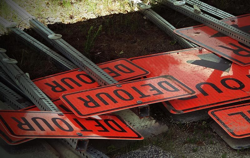 orange detour signs flat on ground