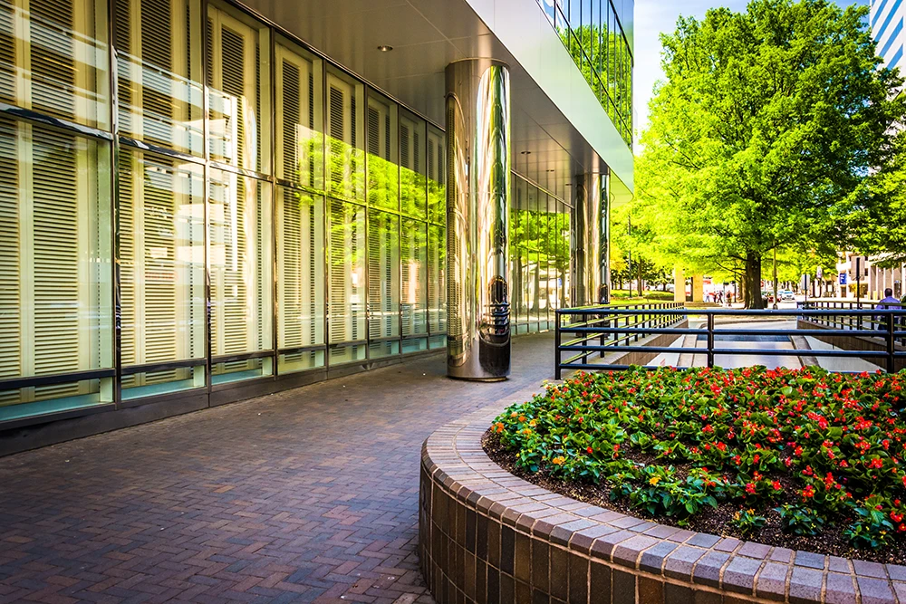 The exterior of a beautiful, modern commercial building with an inviting courtyard and lush landscaping 