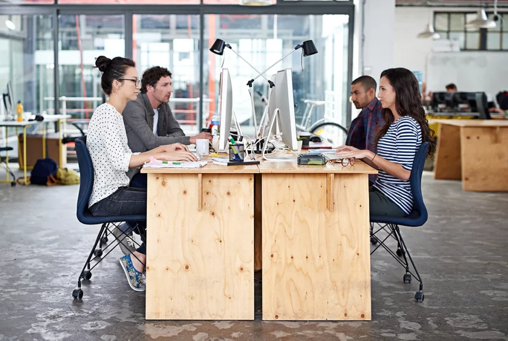 A group of young office workers sitting at their work stations in a modern office building