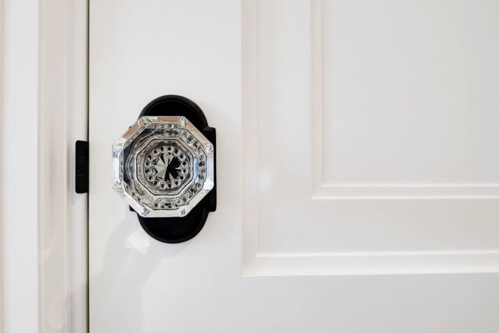 An antique crystal doorknob on a white door helps maintain the historic feel of a home remodel.