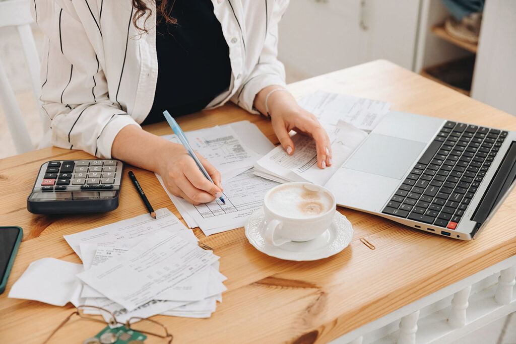 A woman sits at a desk, looking over financial documents to calculate the return on investment of a commercial remodel.