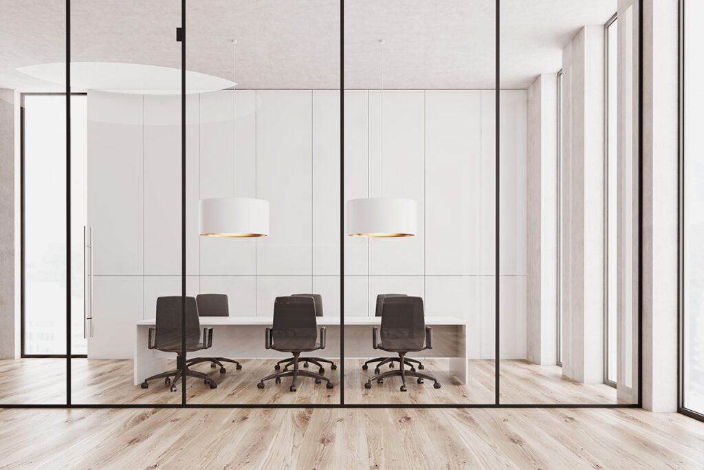 A newly remodeled commercial office conference room with light wood floors and white walls.