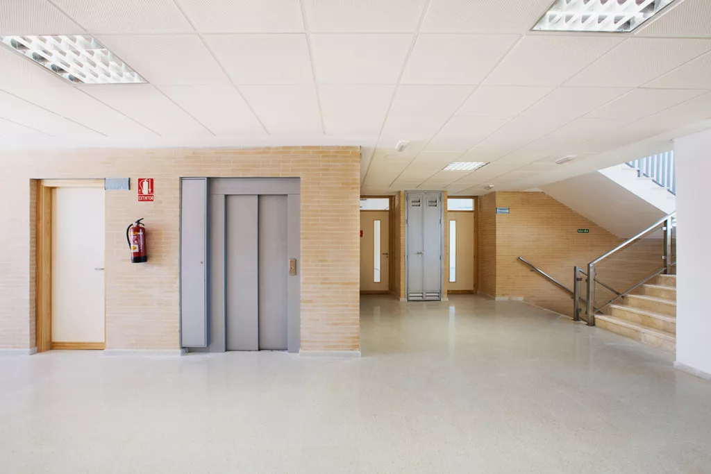 The interior of a public school building, with white linoleum flooring