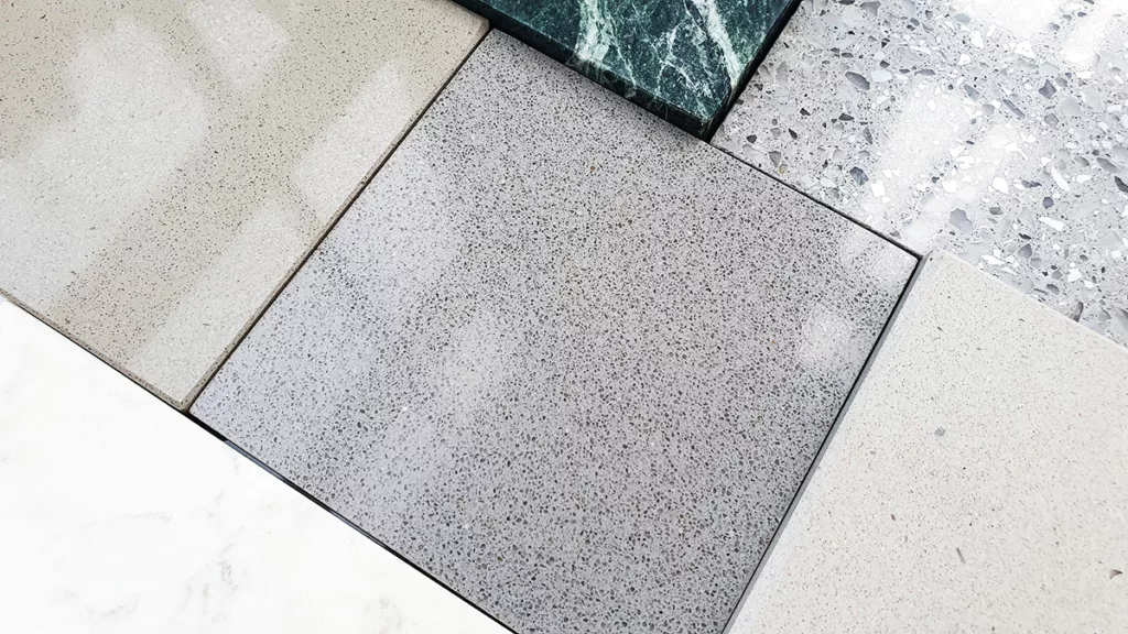 A close up of different quartz flooring options in gray, white, and beige.