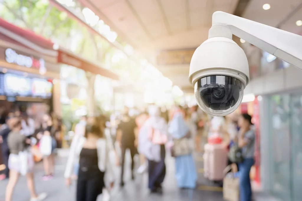 A white security camera outside a retail space, a security upgrade tenant improvement