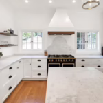 A newly renovated kitchen with white countertops and an antique stove, showing the concept of eco-friendly home renovations