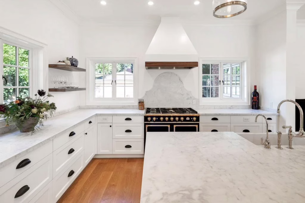 A newly renovated kitchen with white countertops and an antique stove, showing the concept of eco-friendly home renovations