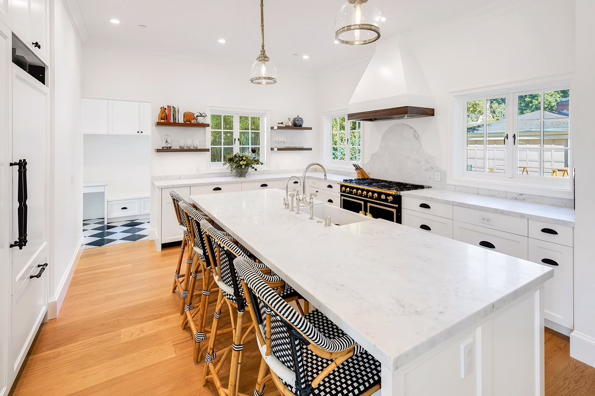 The interior of a newly renovated kitchen with white countertops and hardwood floors